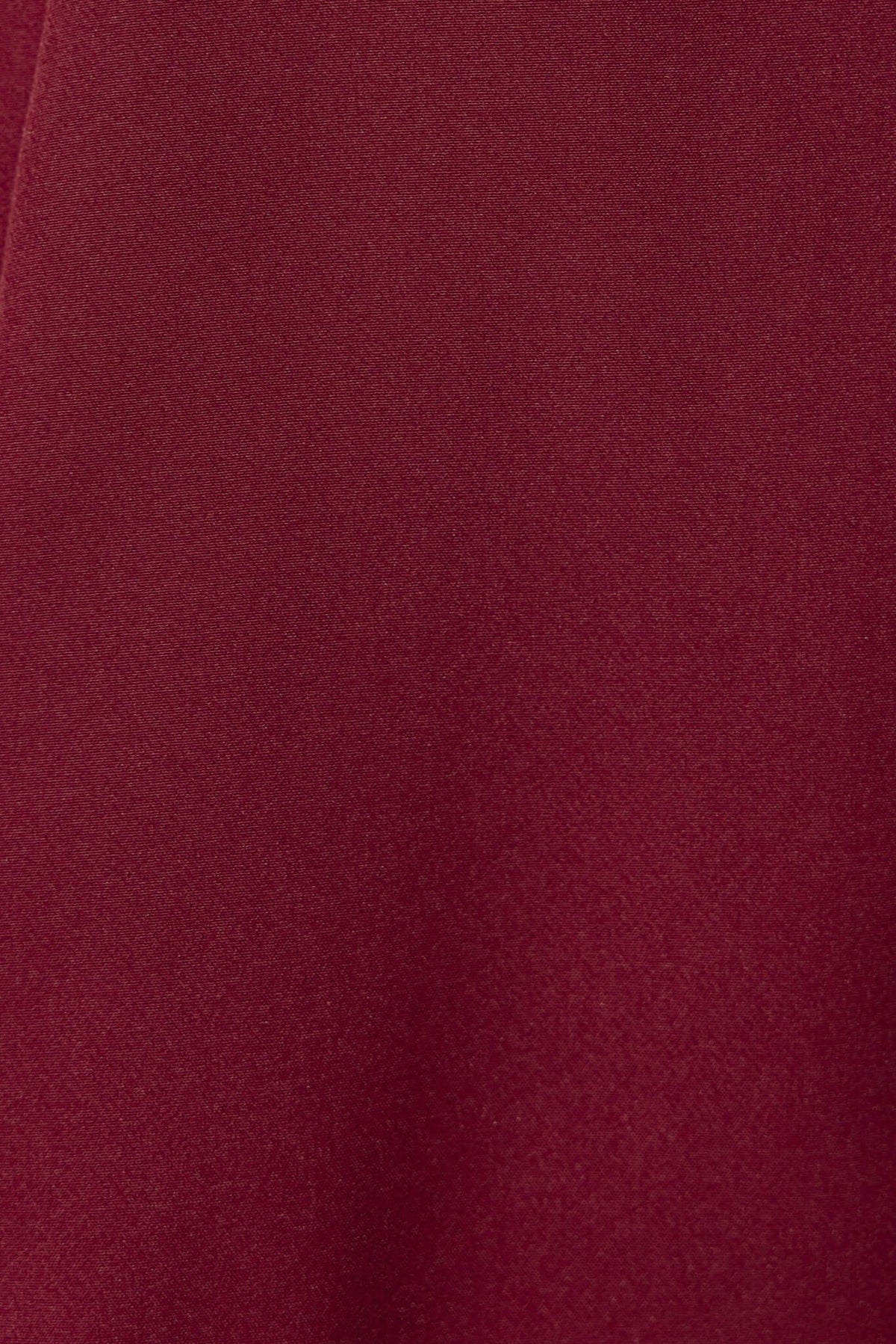 Close-up of the Varis Skirt in deep burgundy fabric, showcasing its smooth texture and high-quality polyester material.