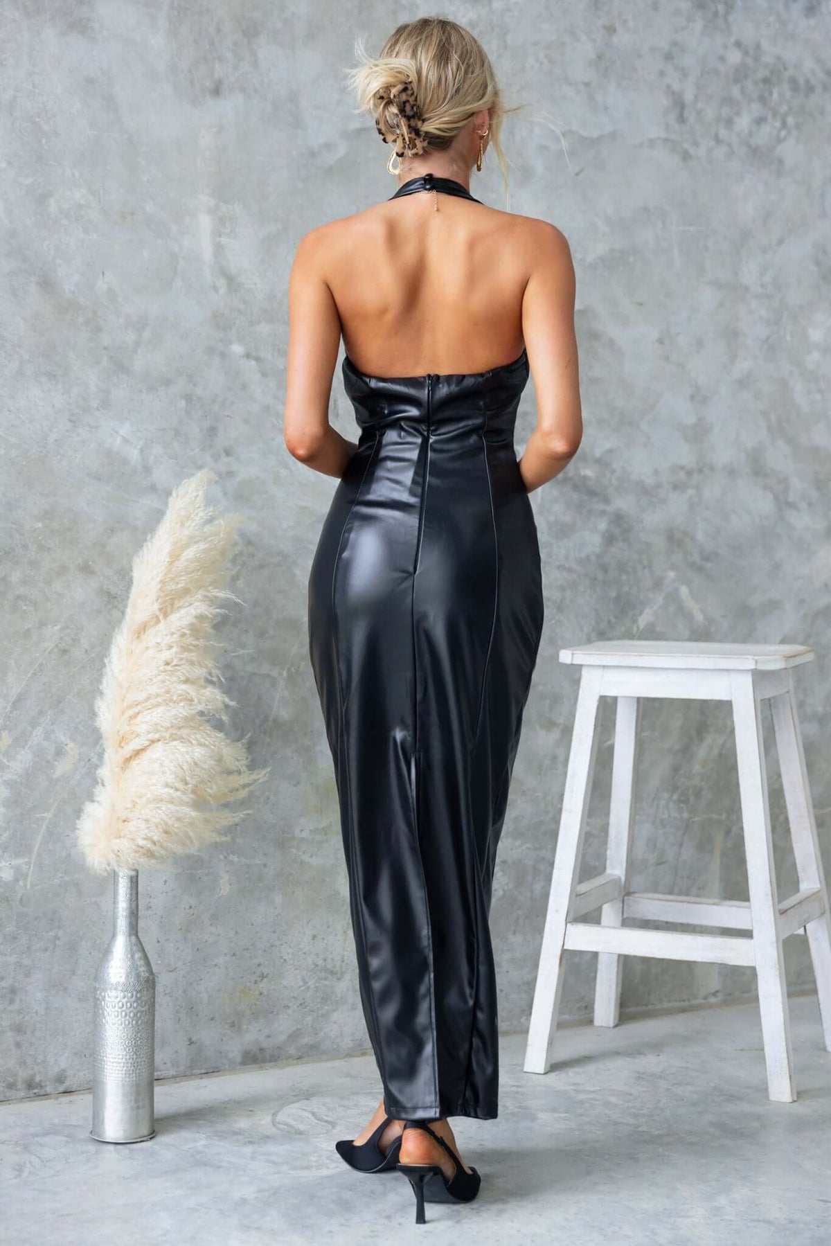 Back view of Veridan Maxi Dress in faux leather with halter neckline and split detail, styled for a chic look.