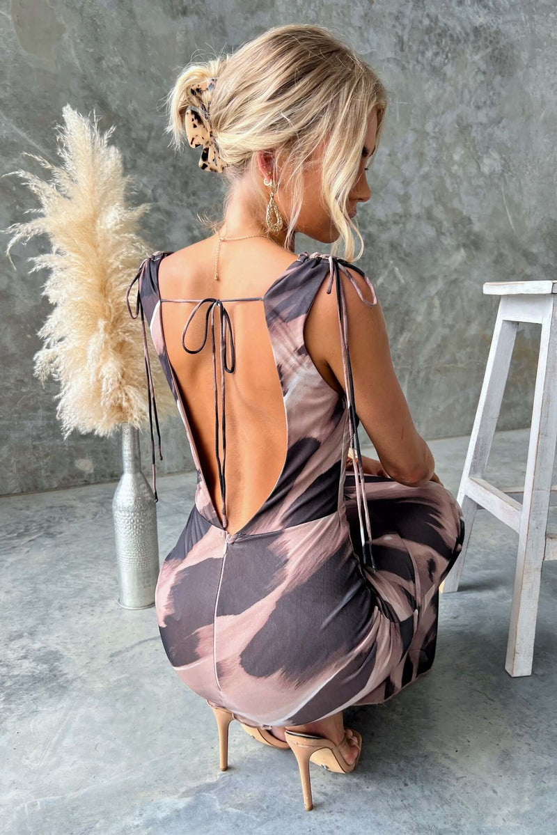 Model wearing Verone Maxi Dress with cowl neckline and tie straps, showcasing low-cut back and stretch fabric.
