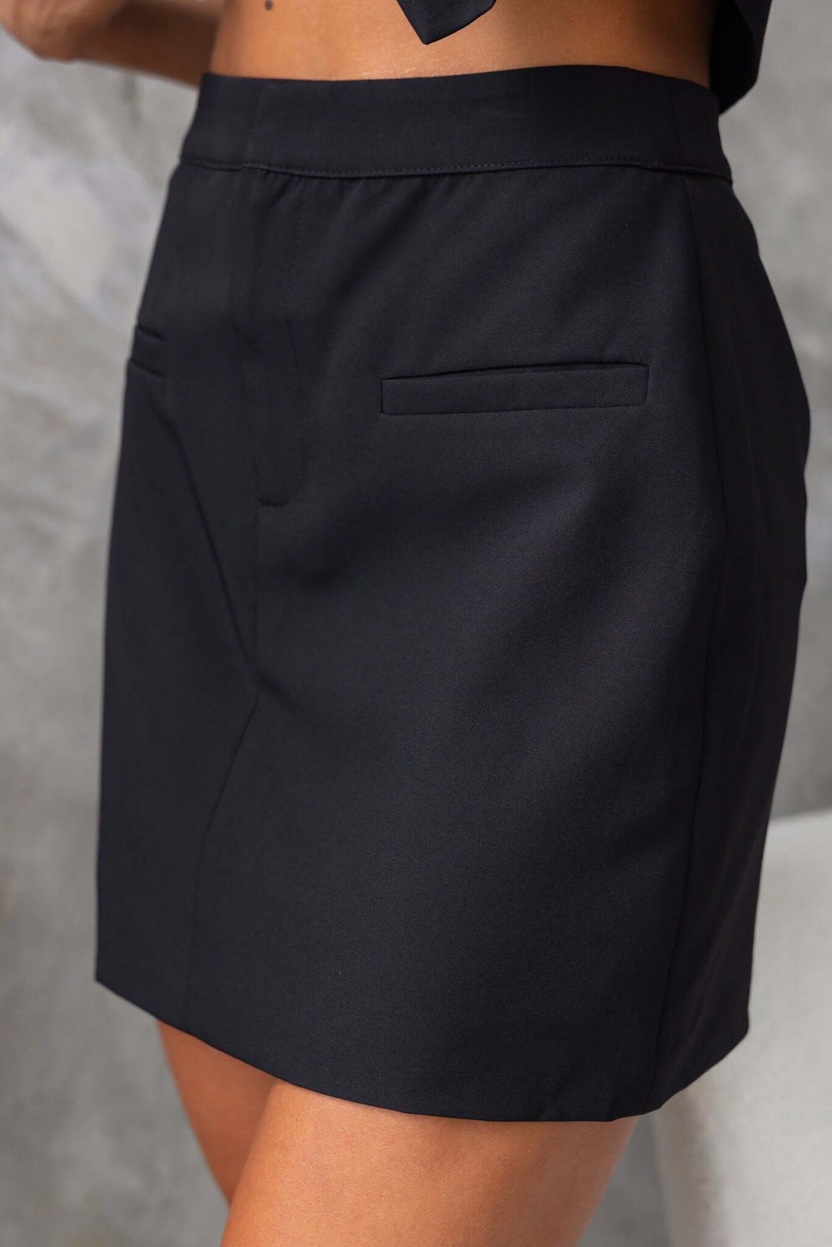 Black mid-high waist Jayne Skirt featuring faux pockets and a simple lined design.