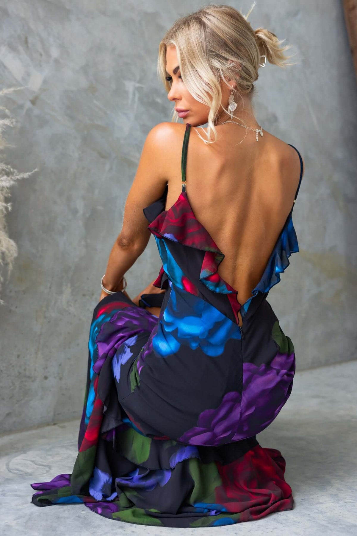 Back view of a floral maxi dress with ruffles and adjustable straps, showcasing elegant style and design.