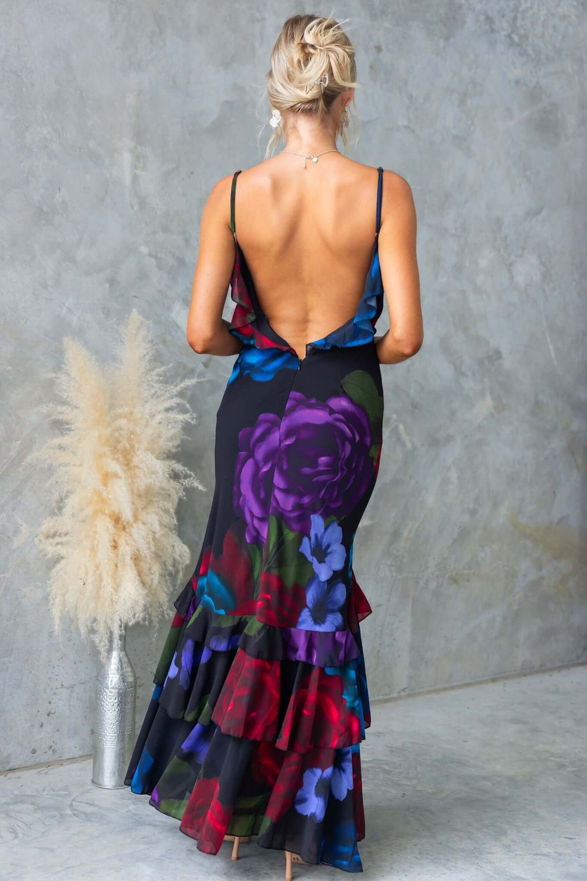 Back view of a floral split maxi dress with ruffles and adjustable straps, perfect for elegant summer occasions.