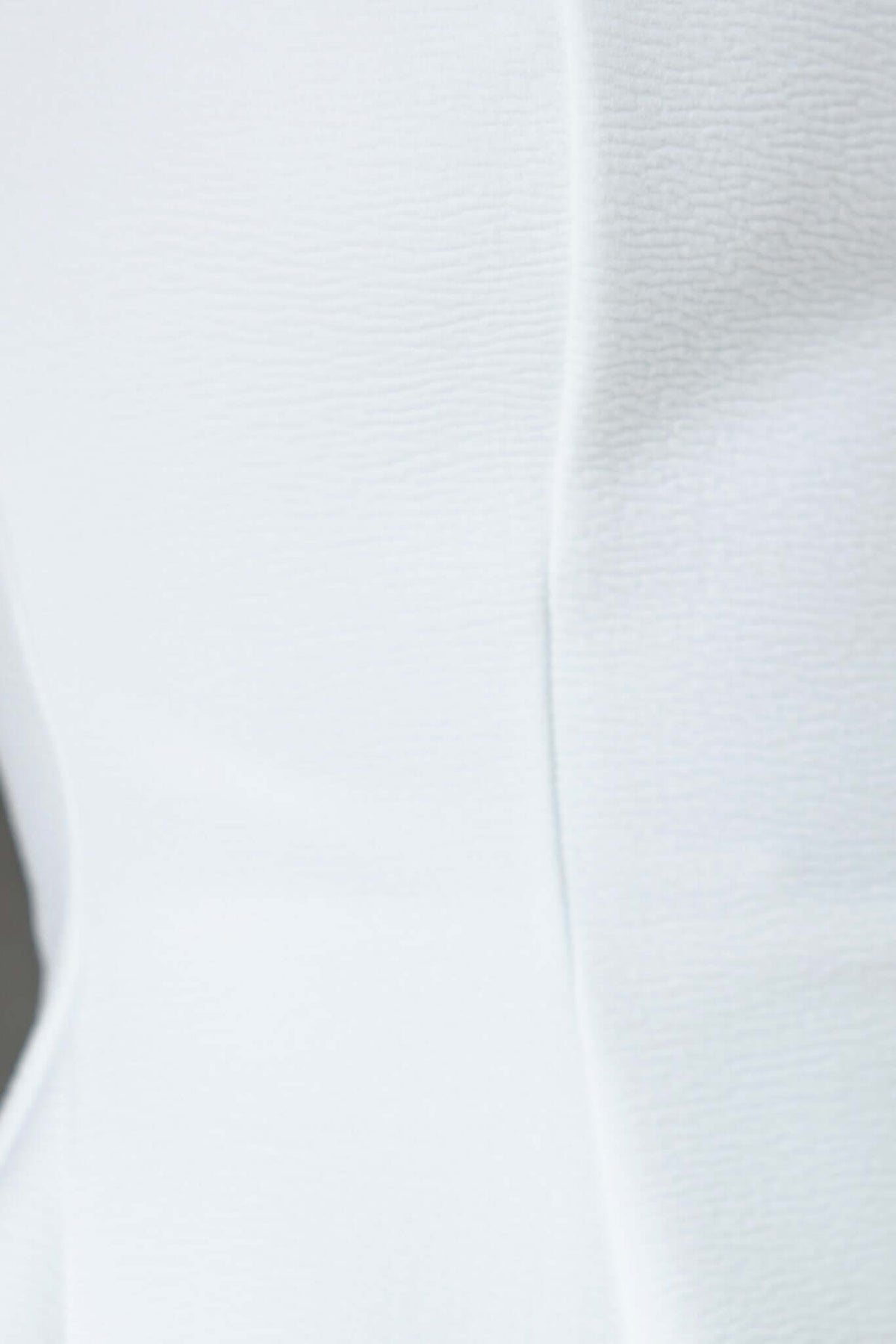 Close-up of textured white fabric, showcasing soft material of the Xander Maxi Dress with stretch and lined bust.