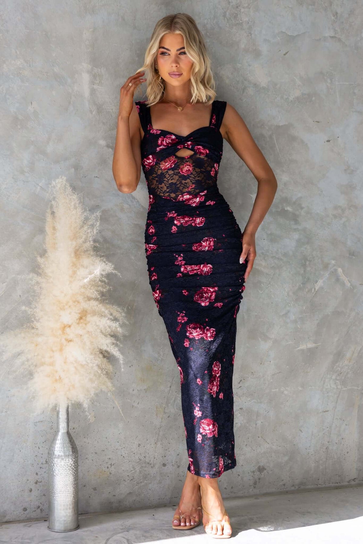 Model wearing the Xavina Maxi Dress, a navy floral twist detail dress with cut-out and ruching.