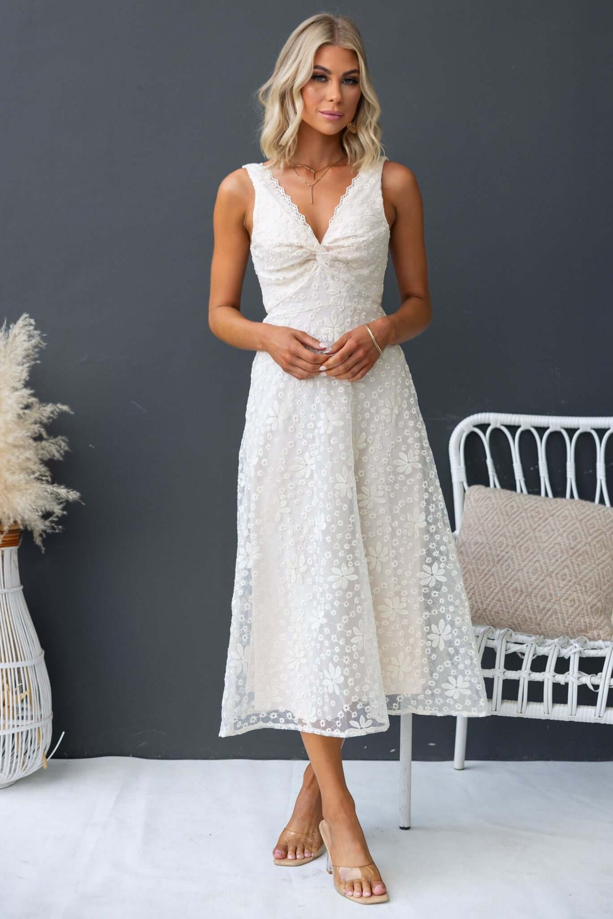 Yakima Midi Dress featuring a twist at the bust, invisible zip, and floral design, styled with a relaxed fit.