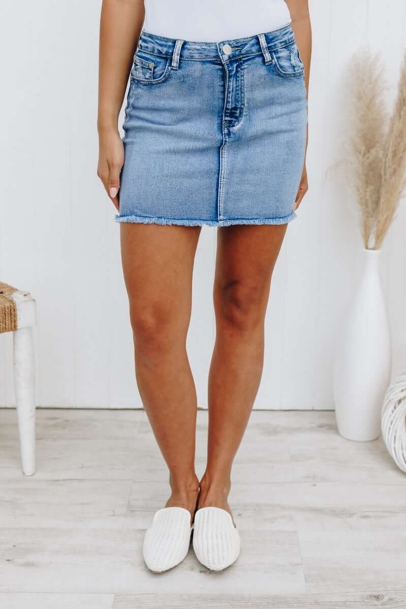 Model wearing Nice For What skirt featuring a raw hemline and distressed pockets, styled in light denim.