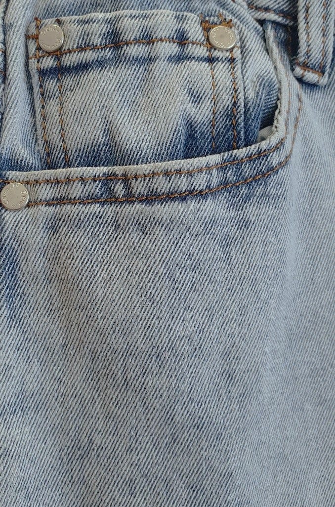 Close-up of Valley Jeans showcasing slight acid wash and raw hemline detailing.