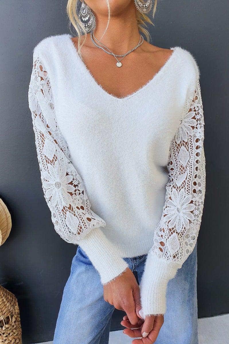 Indya jumper featuring a fluffy knit design, V-neckline, and lace sleeves on a model wearing casual denim.