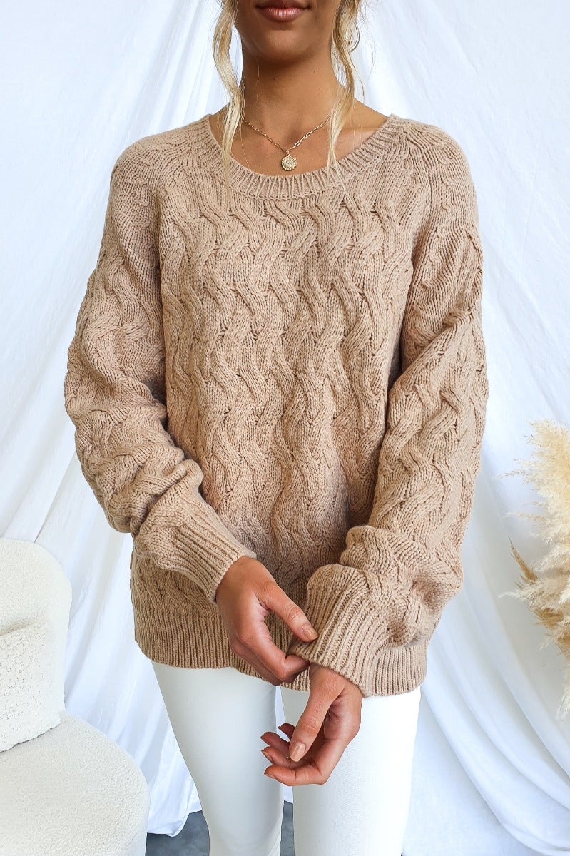 Renee Jumper in cable knit style, featuring a round neckline and relaxed fit, demonstrated by a model wearing white pants.