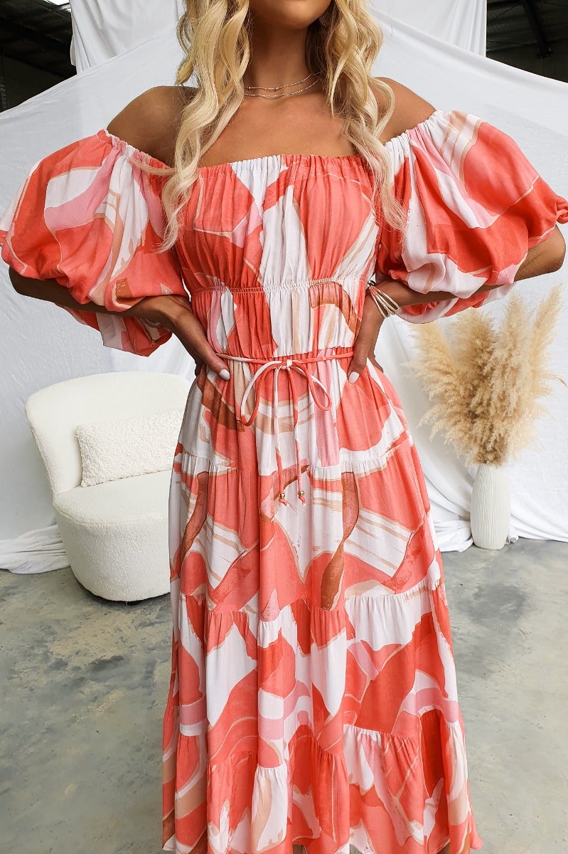 Model wearing a Quetta Midi Dress in multi-colour print with elastic neckline and puff sleeves.