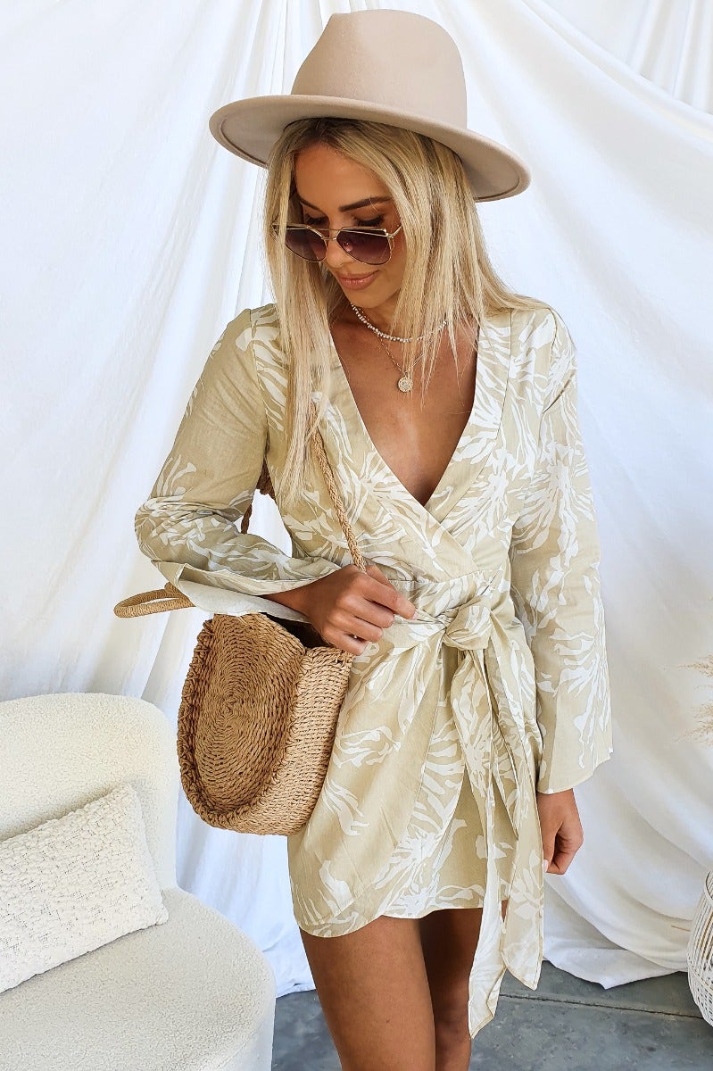 Floral print V-neck dress with a tie, styled with a hat and sunglasses, perfect for casual summer outings.