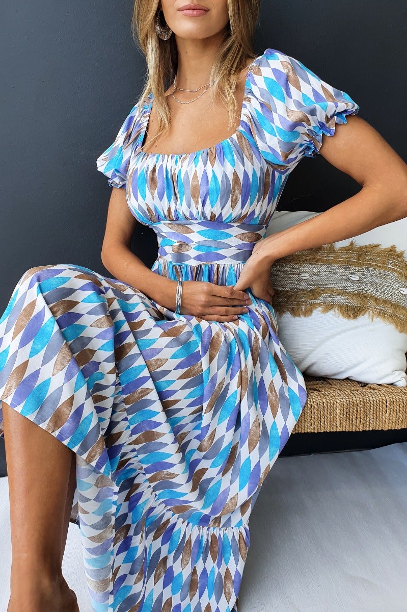 Model wearing the Garland Midi Dress featuring a multi-colour print, sweetheart neckline, and puffed sleeves.