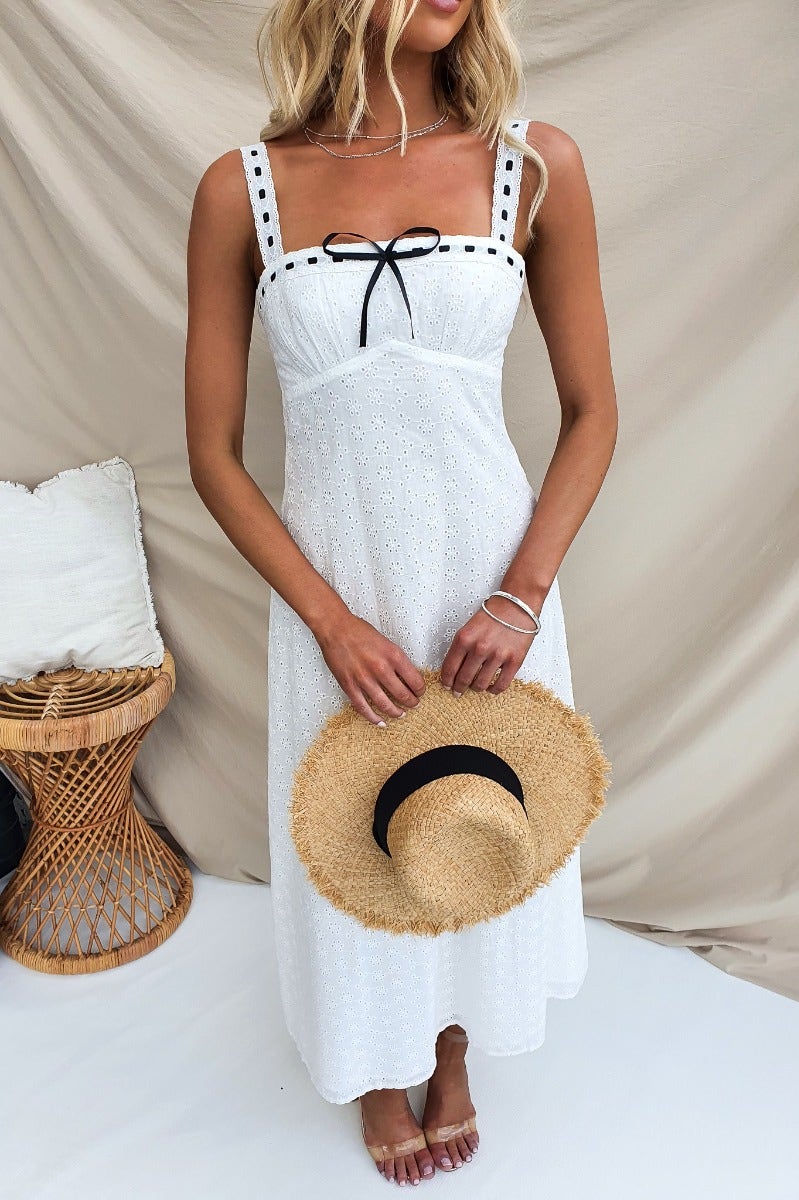 Cottage Dreams Maxi Dress in white with adjustable straps and ribbon detailing, styled for a summer look.