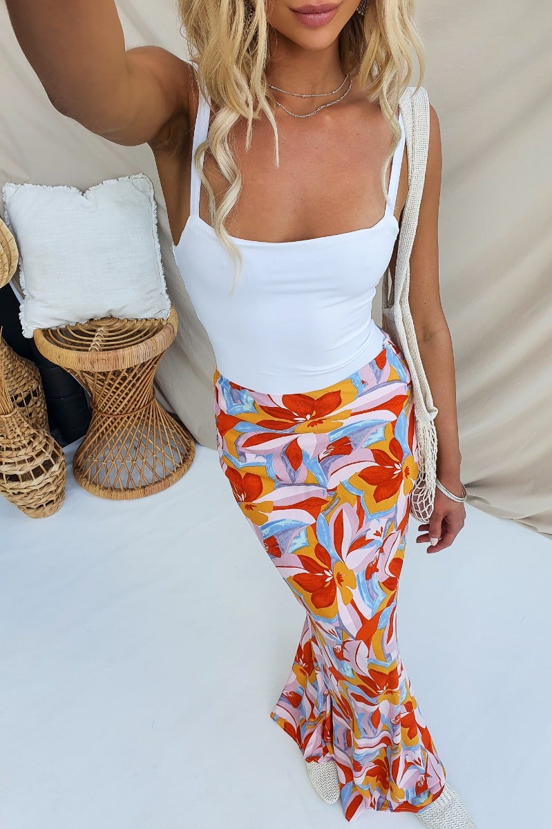 Model wearing Heartful Maxi Skirt with floral print, paired with a white top, showcasing a stylish summer outfit.