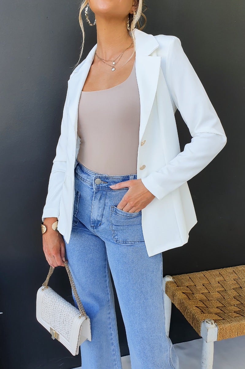 Stylish Edin Blazer worn with a beige top and high-waisted jeans, featuring a white color and chic button-up design.