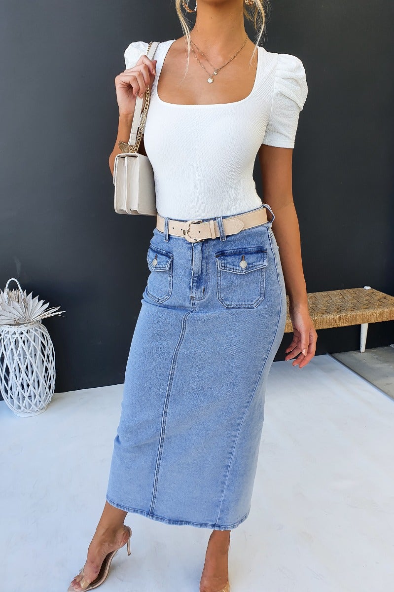 Model wearing Mora Denim Midi Skirt with mid-high waist, front and back pockets, and back split.