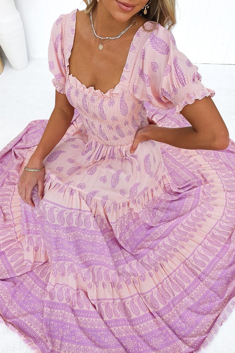 Multi-colour maxi dress featuring an elastic bodice and sleeves, styled with intricate pink and purple patterns.