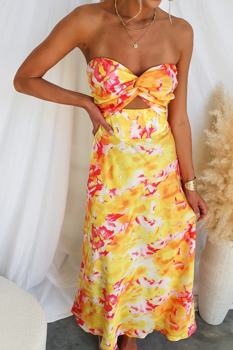 Model wearing a vibrant yellow and pink Electric Touch Maxi Dress with strapless cut and cut-out detail.