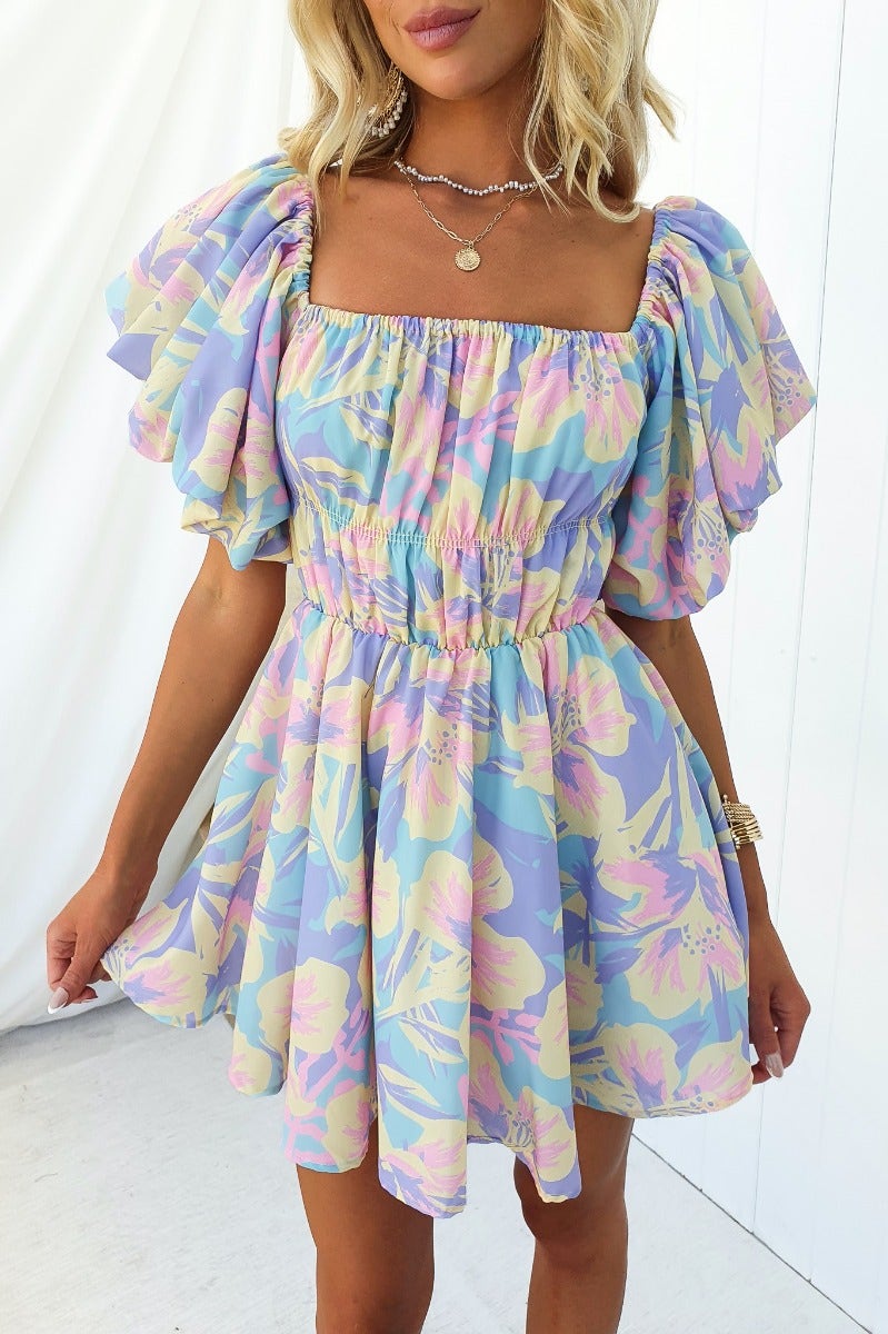 Claire Dress featuring an off-shoulder neckline, gathered bodice, and floral pattern on a mini silhouette.