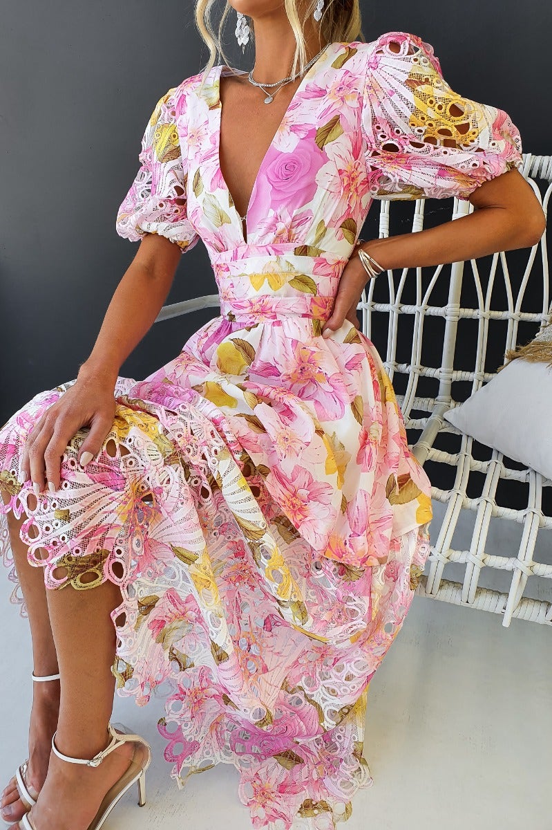 Model wearing a floral print Forever Free Maxi Dress with V-neckline and puff sleeves, styled with elegant accessories.