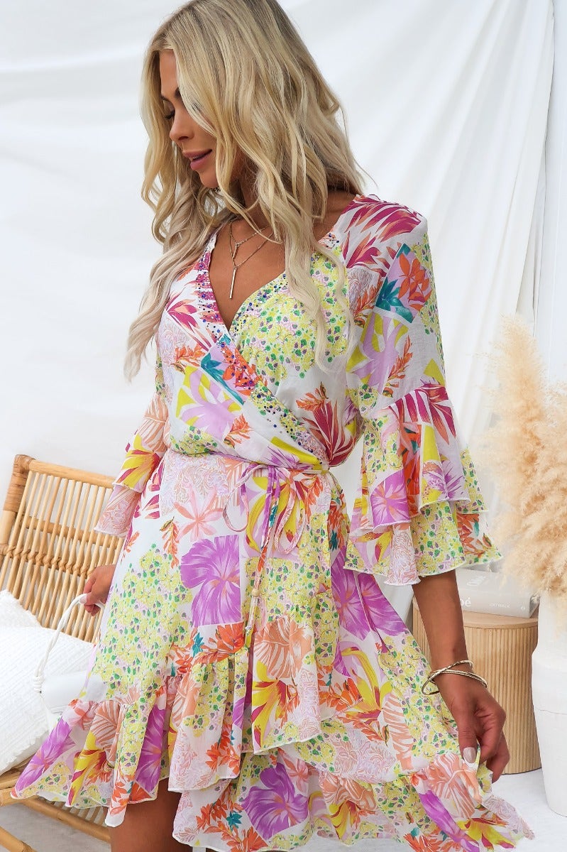 Fools Gold wrap dress featuring a V-neckline, floral print, and ruffles, perfect for summer occasions.