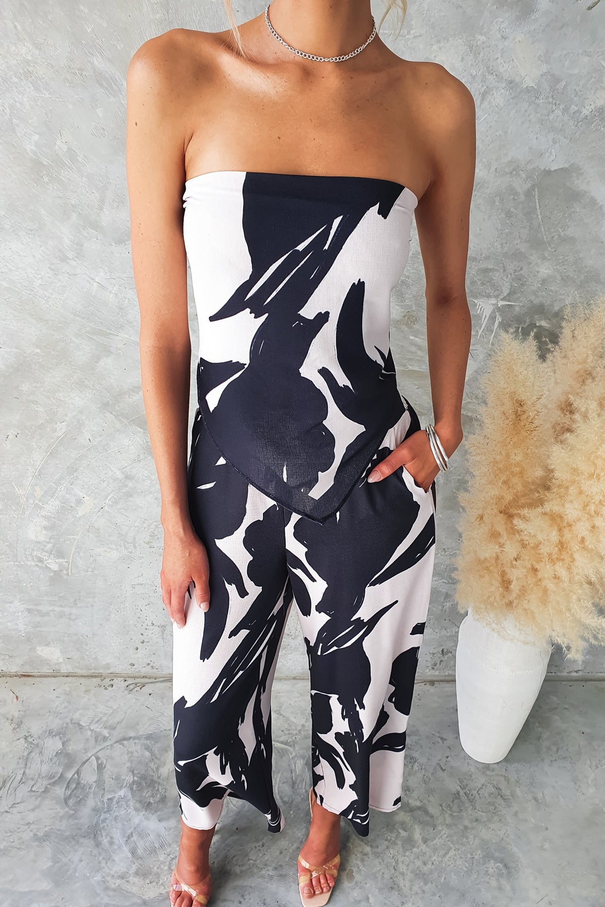 Stylish black and white print strapless jumpsuit featuring a relaxed fit and side pockets.