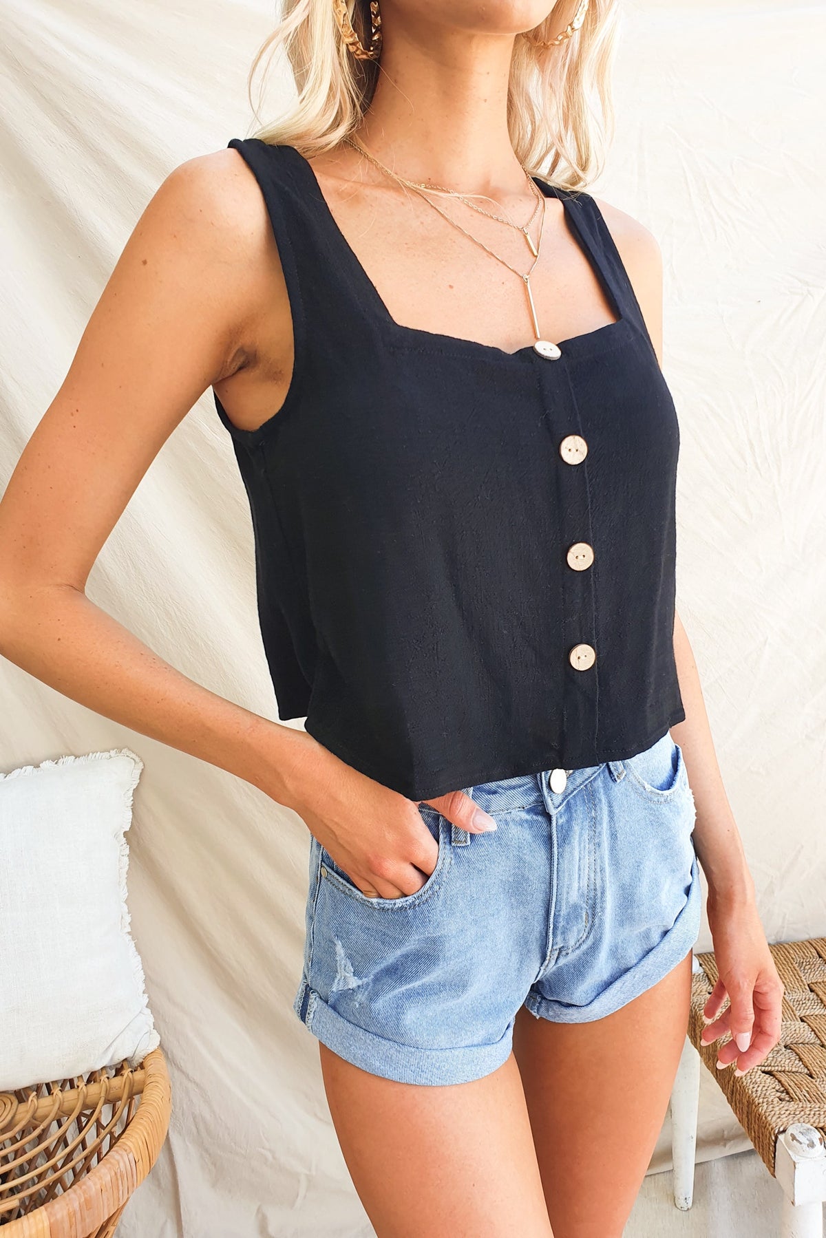 Black Jaye Top with square neckline and faux buttons, styled with denim shorts and layered necklaces.