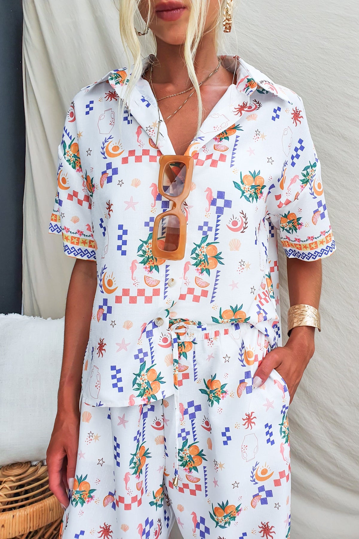 Talei Shirt featuring an abstract print, button-up front, and linen-cotton blend fabric, styled with sunglasses.
