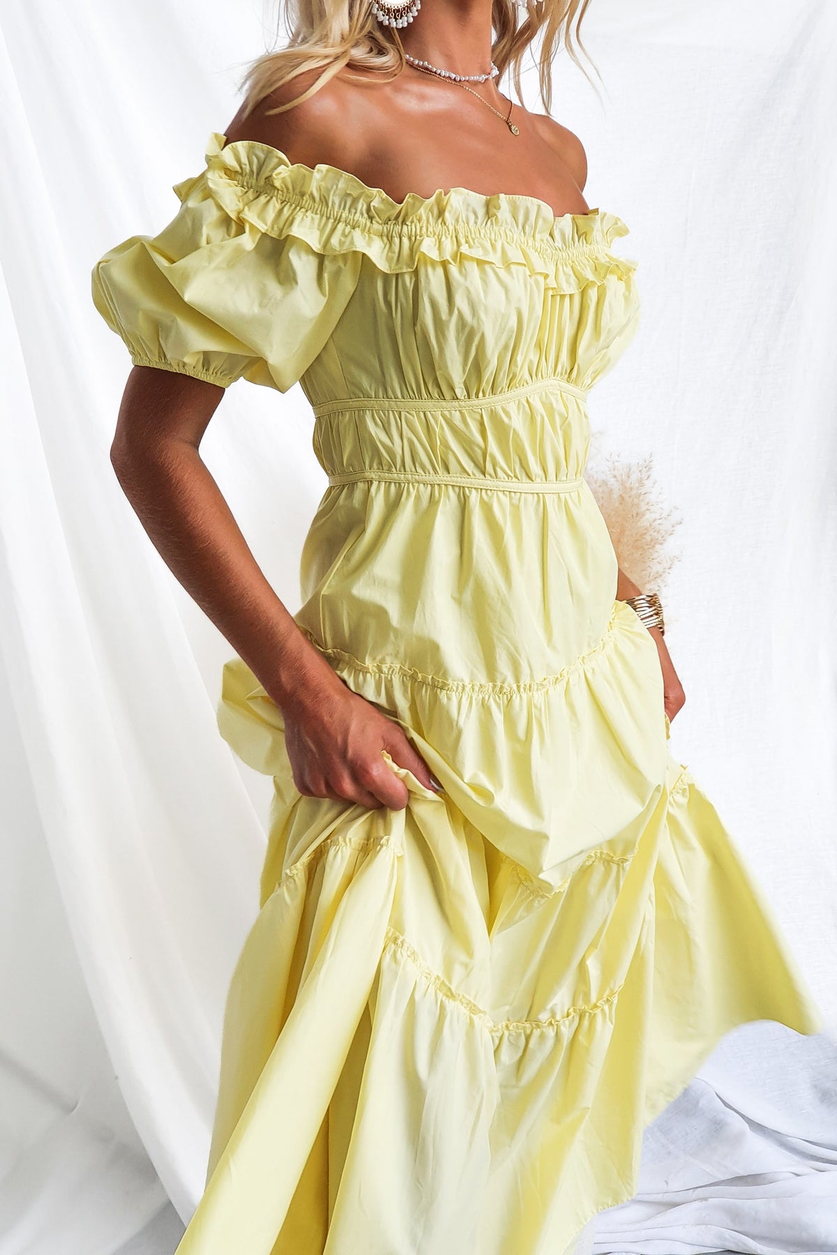 Archer Maxi Dress in soft yellow, featuring off-shoulder neckline, ruffled sleeves, and tiered design.
