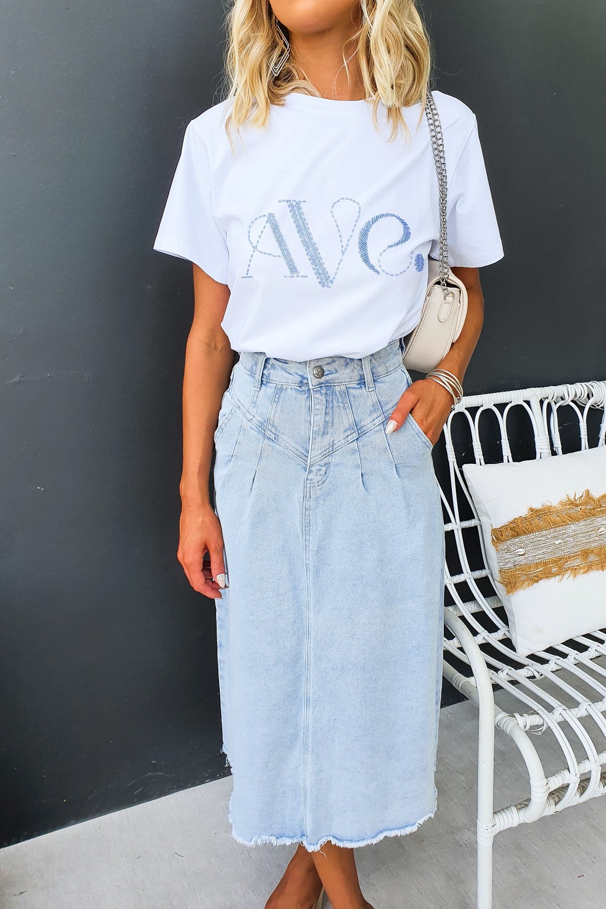 Woman wearing Emera Denim Midi Skirt with high waist and frayed hem, styled with a white tee for a casual outfit.