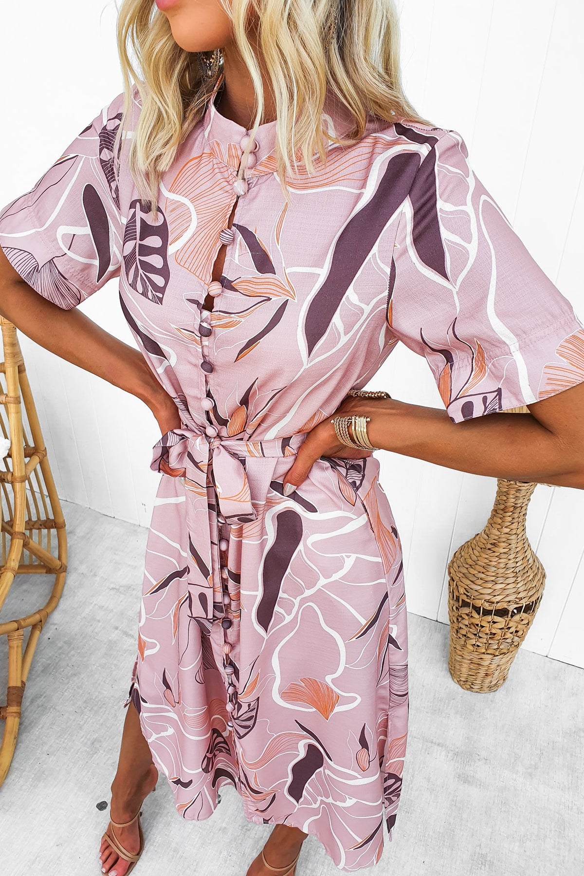 Model wearing a Jubell Midi Dress with floral design, button-up front, and removable tie, styled in a bright setting.