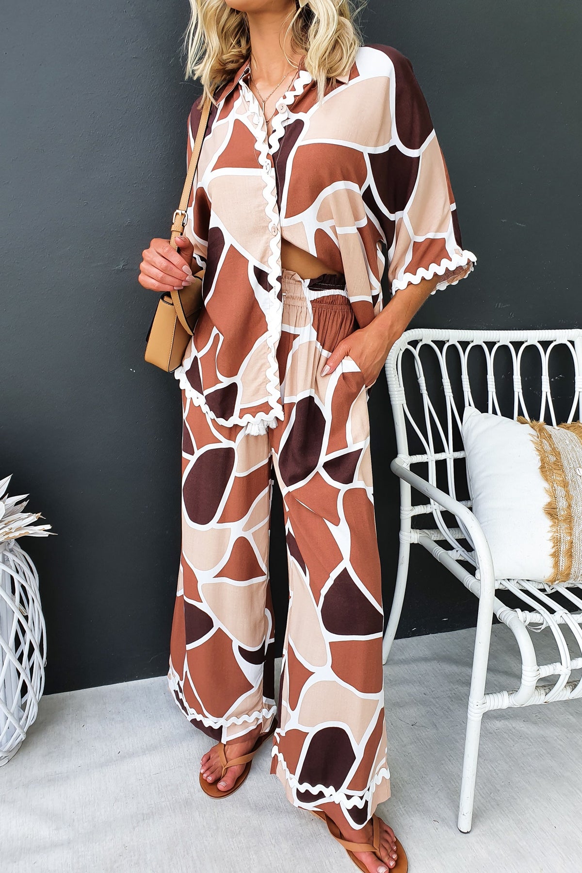 Model wearing Maito Pants with a mid-high waist, elastic waistband, and stylish brown pattern, paired with a matching top.