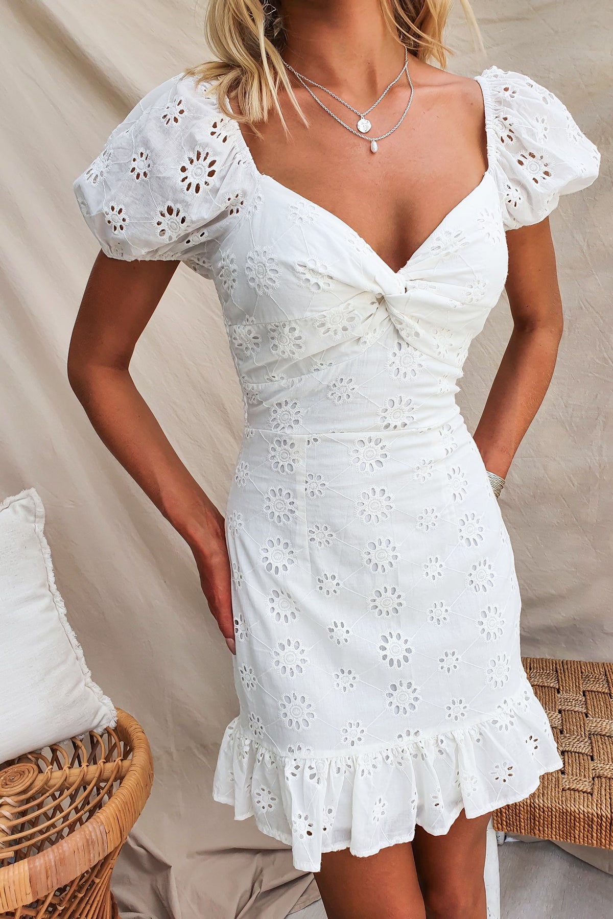 Elida Dress with twist detail, puff sleeves, and Anglaise material, featuring a ruffled hem and elegant design.