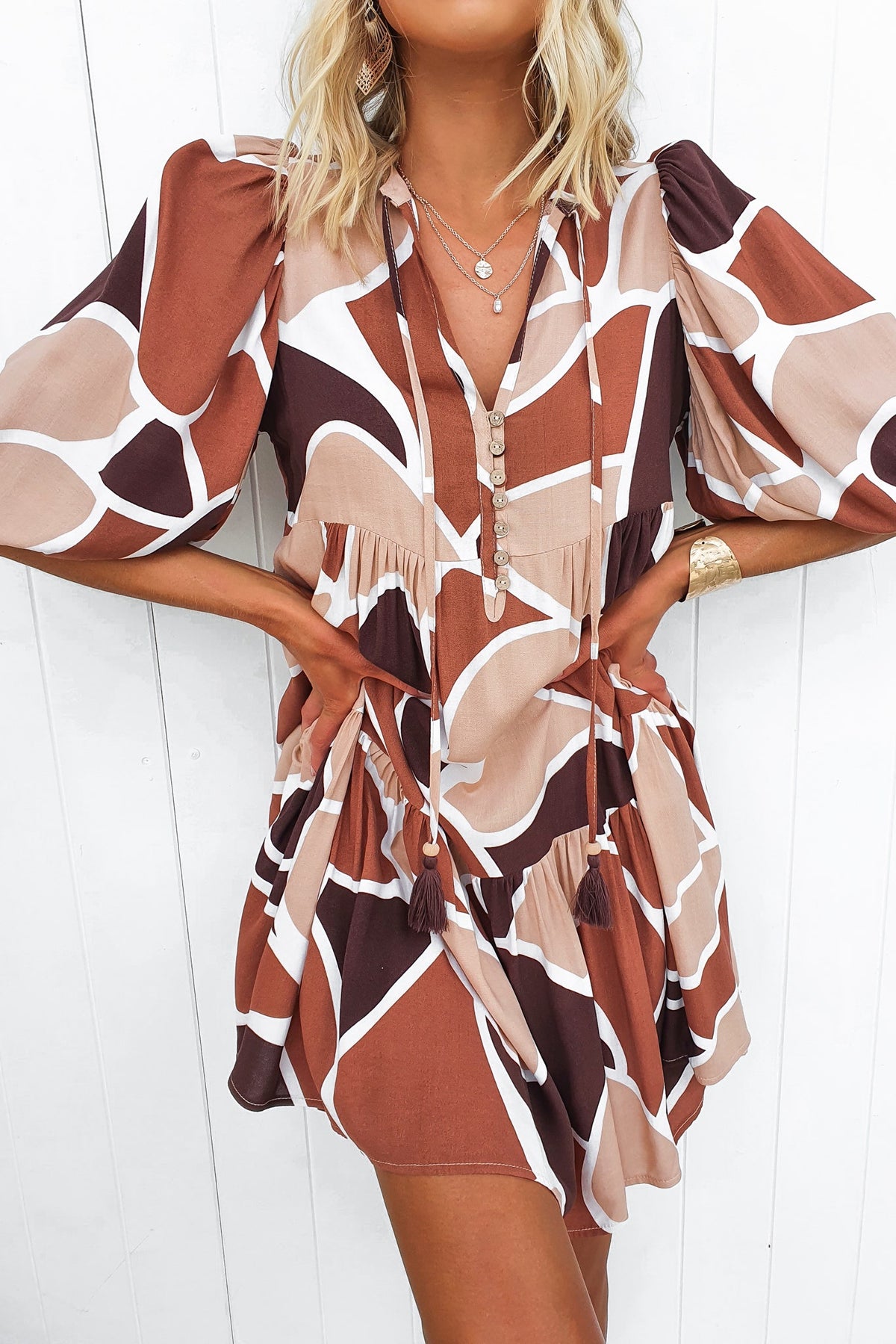 Alisti Dress featuring V-neckline, tie detail, and unique geometric print in earthy colors, perfect for a relaxed fit.