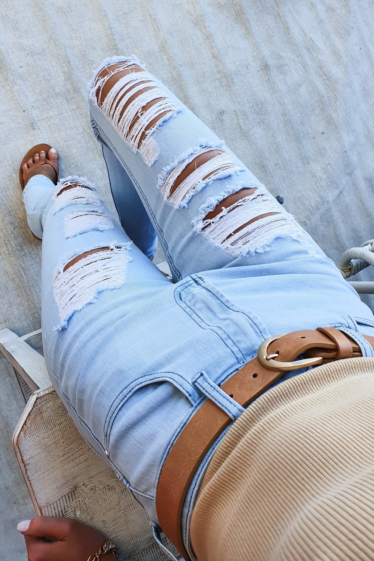 Milos Jeans featuring a mid-high waist fit with distressed rips and pockets, styled with a casual outfit.