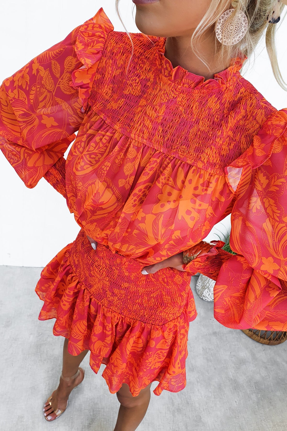 Ginevra Dress featuring vibrant floral patterns, high elastic neckline, and flared sleeves for a chic summer look.