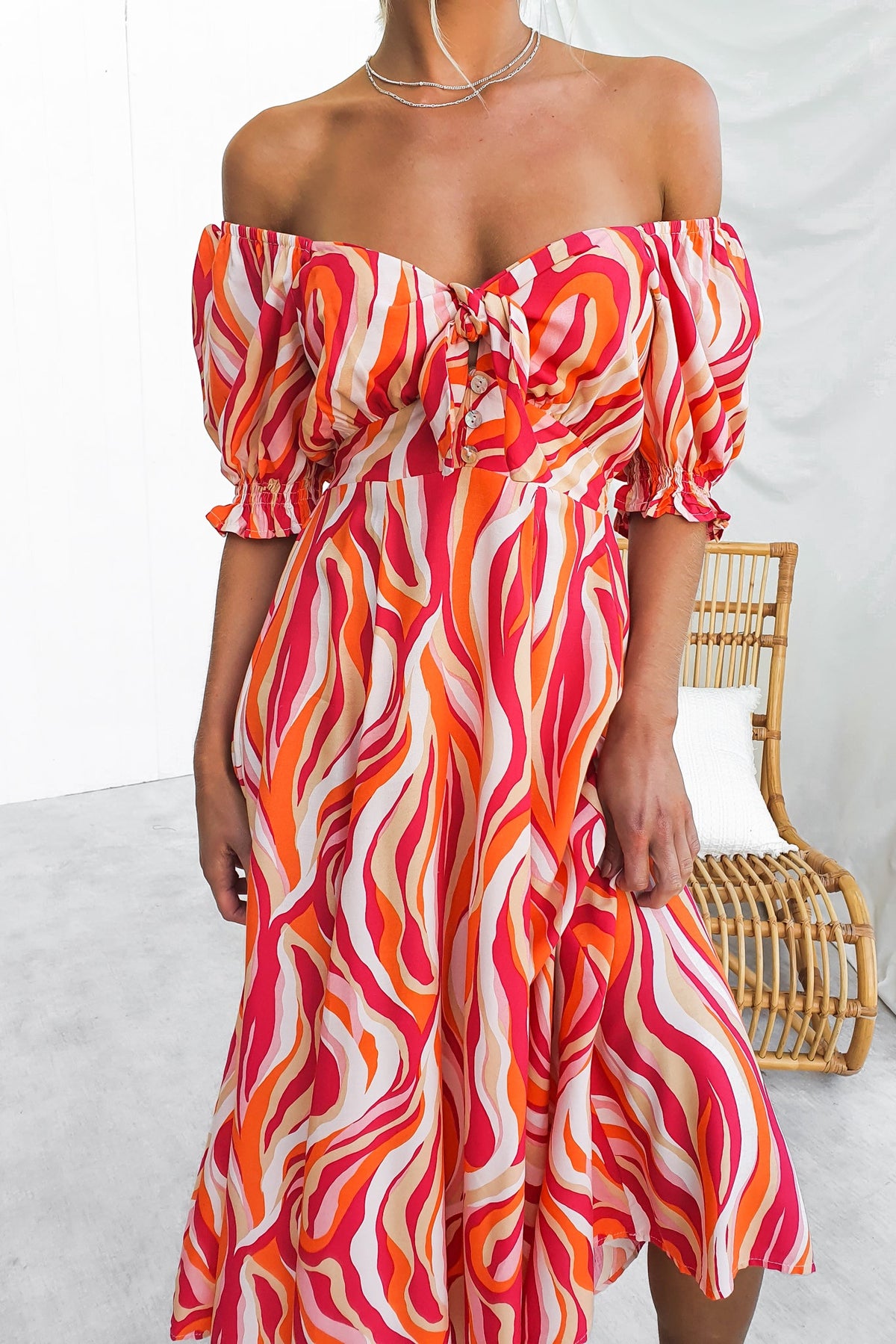 Rayanna Midi Dress featuring a colorful wave pattern, off-shoulder design, and tie detail at the bust for a stylish summer look.