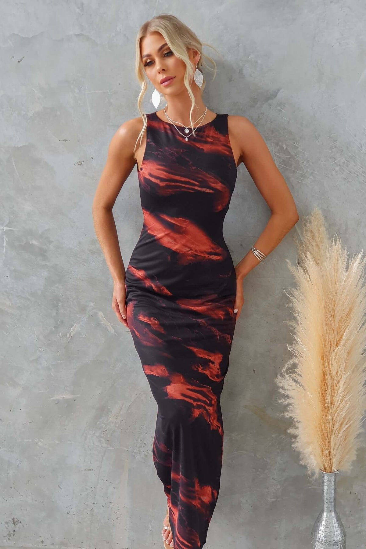 Stylish black and orange patterned maxi dress with a sleek fit, perfect for any occasion.