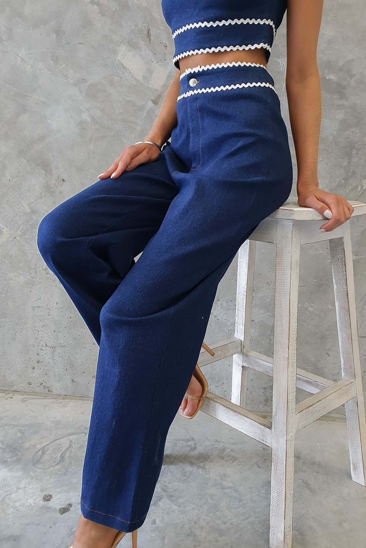 Model wearing Favara Jeans in dark denim with mid-high waist fit, paired with a matching cropped top.