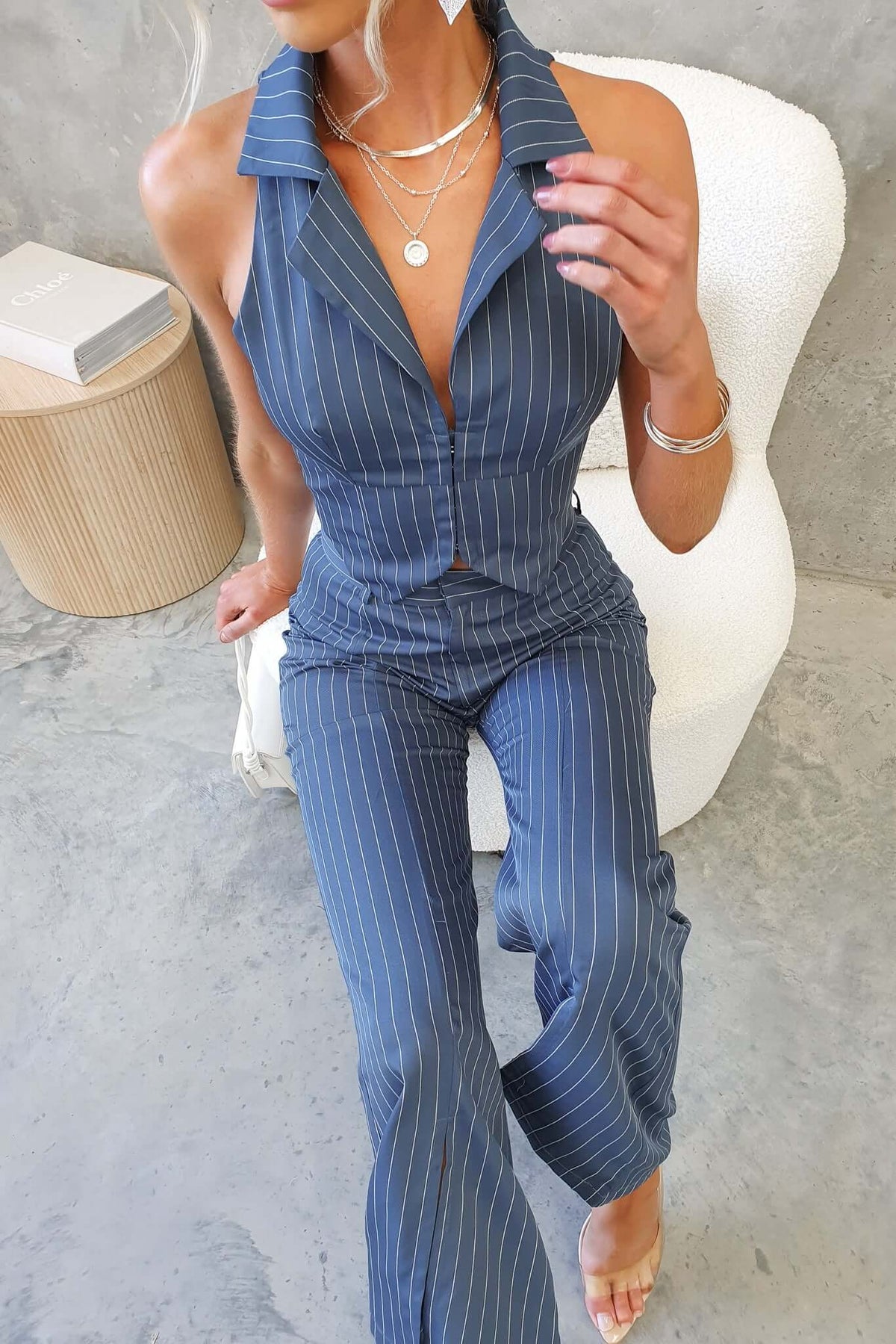 Model wearing Lanai Top with striped design, featuring a collar and fitted style, styled with layered jewelry.