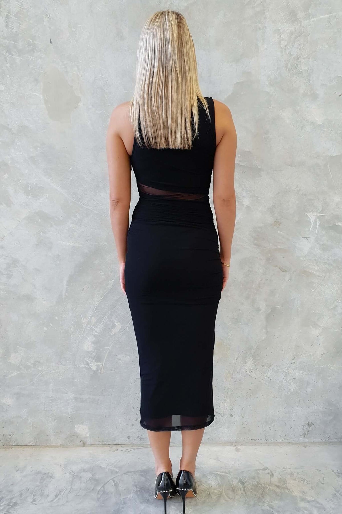 Back view of a woman wearing the Zenallo Black Midi Dress, featuring a fitted design and mesh material.