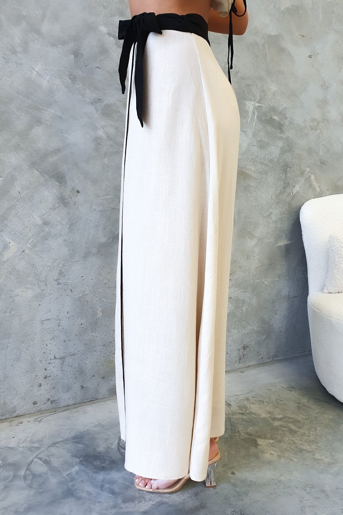 Tuscan Wrap Maxi Skirt featuring a high waist, asymmetric hemline, and a stylish black tie detail.