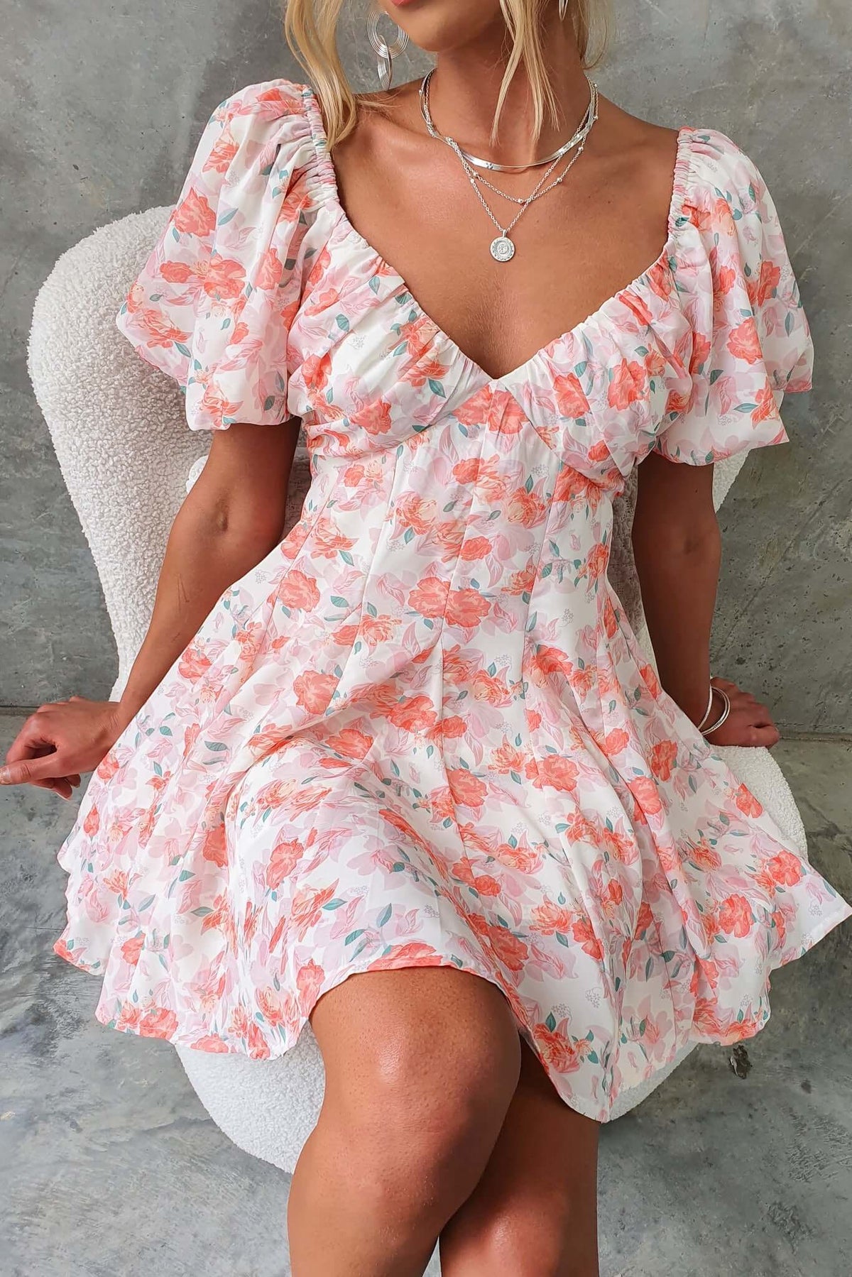 Floral Feel Good Dress with puff sleeves and low-cut back, styled with delicate jewelry, perfect for casual occasions.