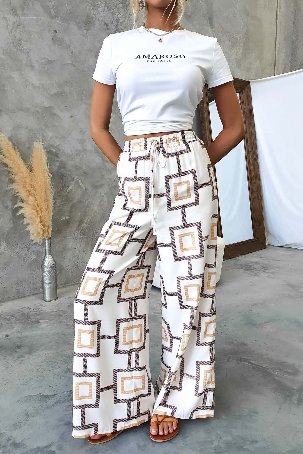 Aiden Pants featuring a mid-high waist fit, elastic waistband, and trendy geometric pattern in a stylish casual setting.