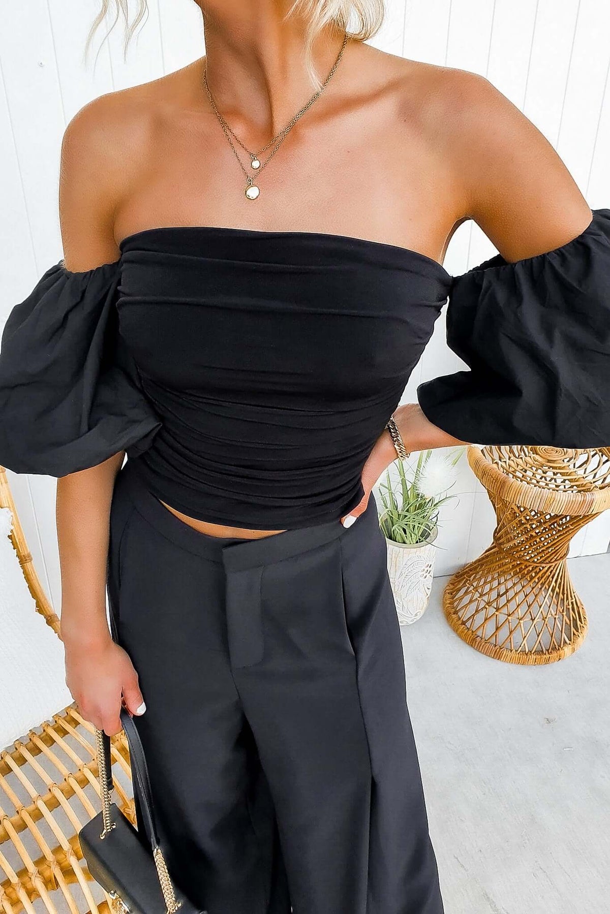 Ivita Top in black, off-shoulder style with puff sleeves and ruched design, paired with stylish high-waisted pants.