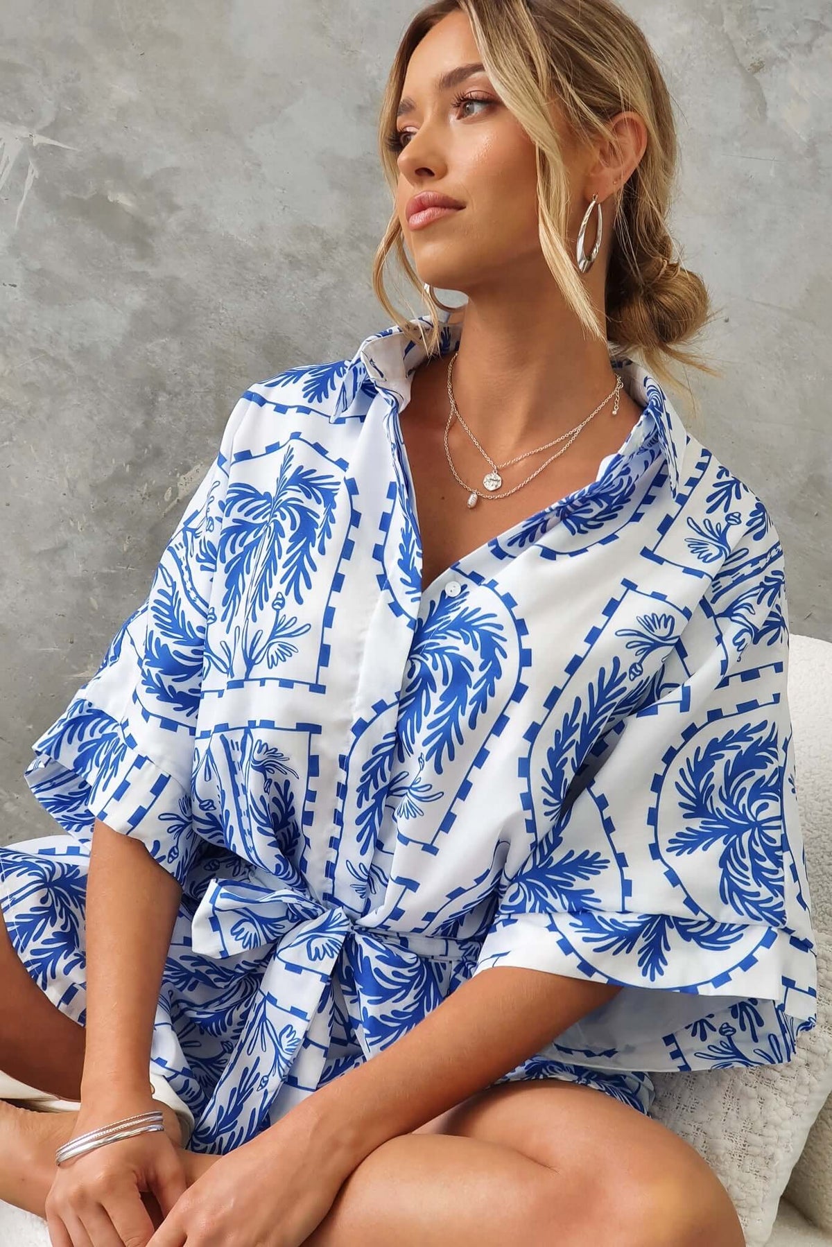 Model wearing blue and white floral printed Alli Playsuit with collar and removable tie, showcasing oversized fit.
