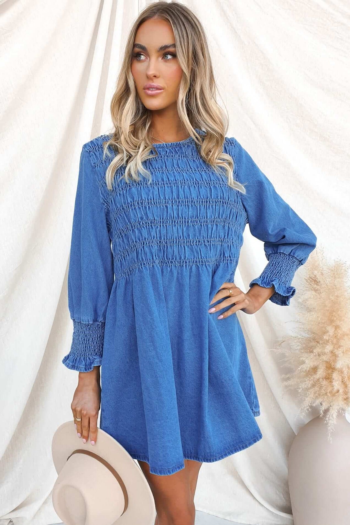 Model wearing Tulsa Denim Dress with elastic bust and sleeves, showcasing relaxed fit and stylish blue denim fabric.