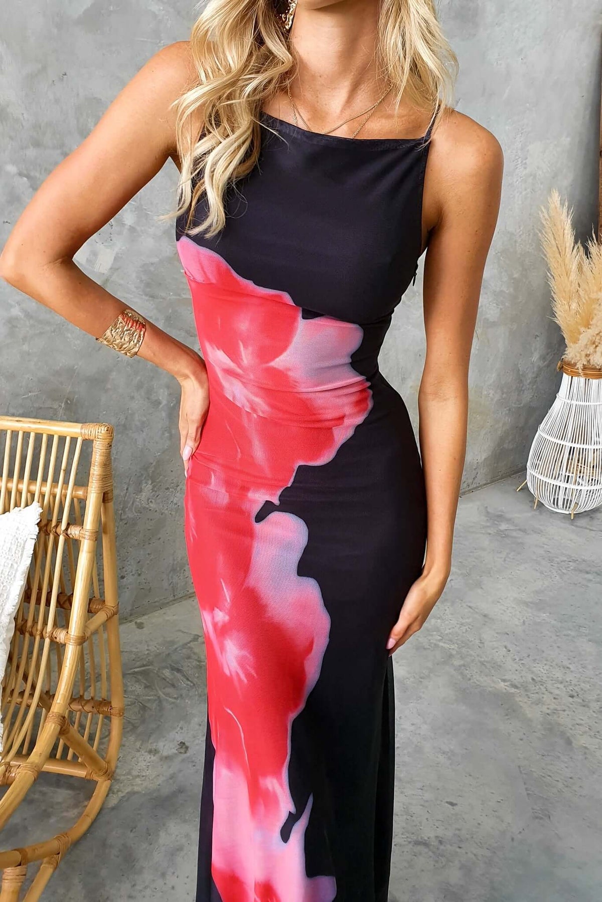 Model wearing black Lyra maxi dress with pink floral design and square neckline, perfect for summer fashion.