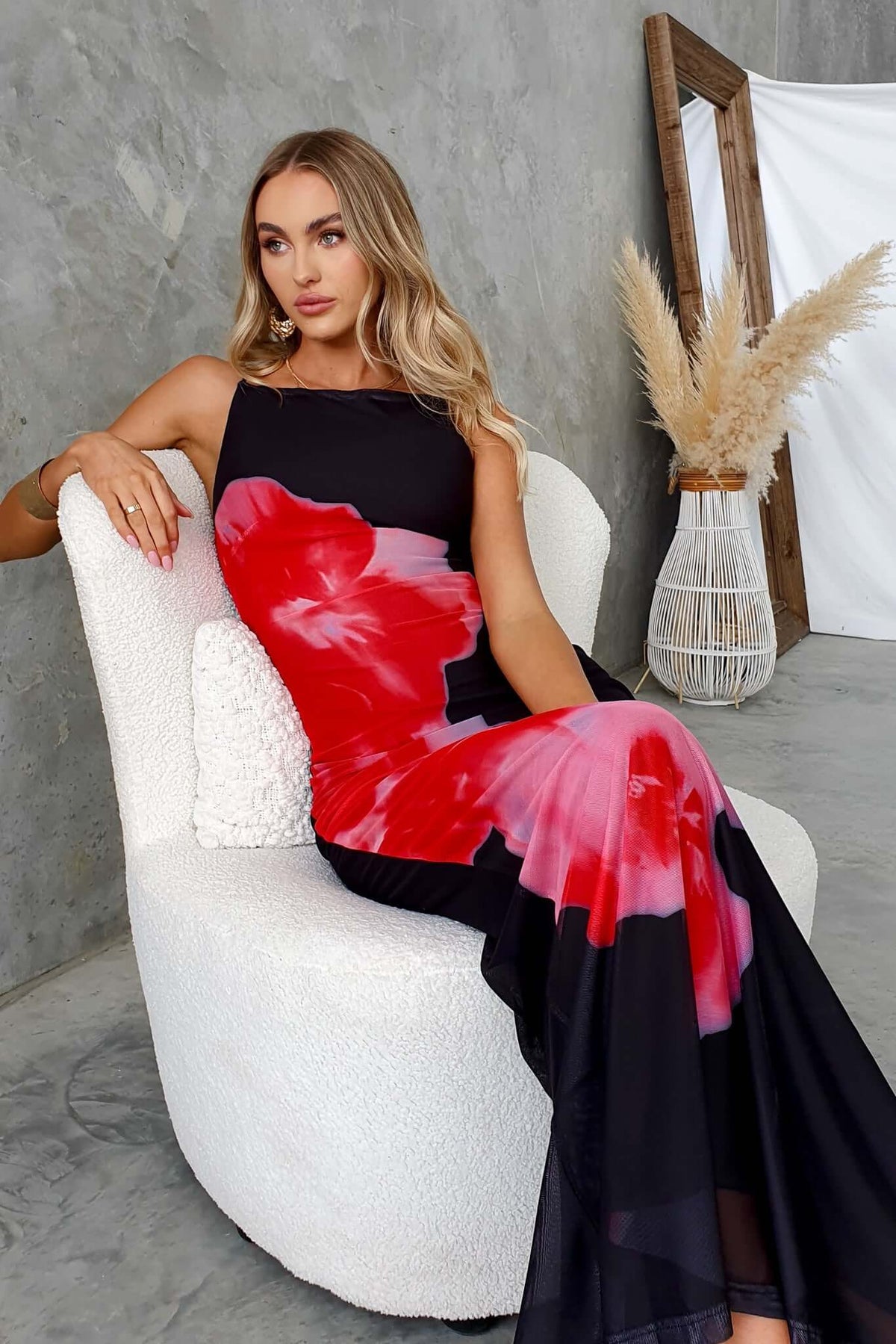 Elegant black maxi dress with red floral print, featuring a square neckline and adjustable straps.