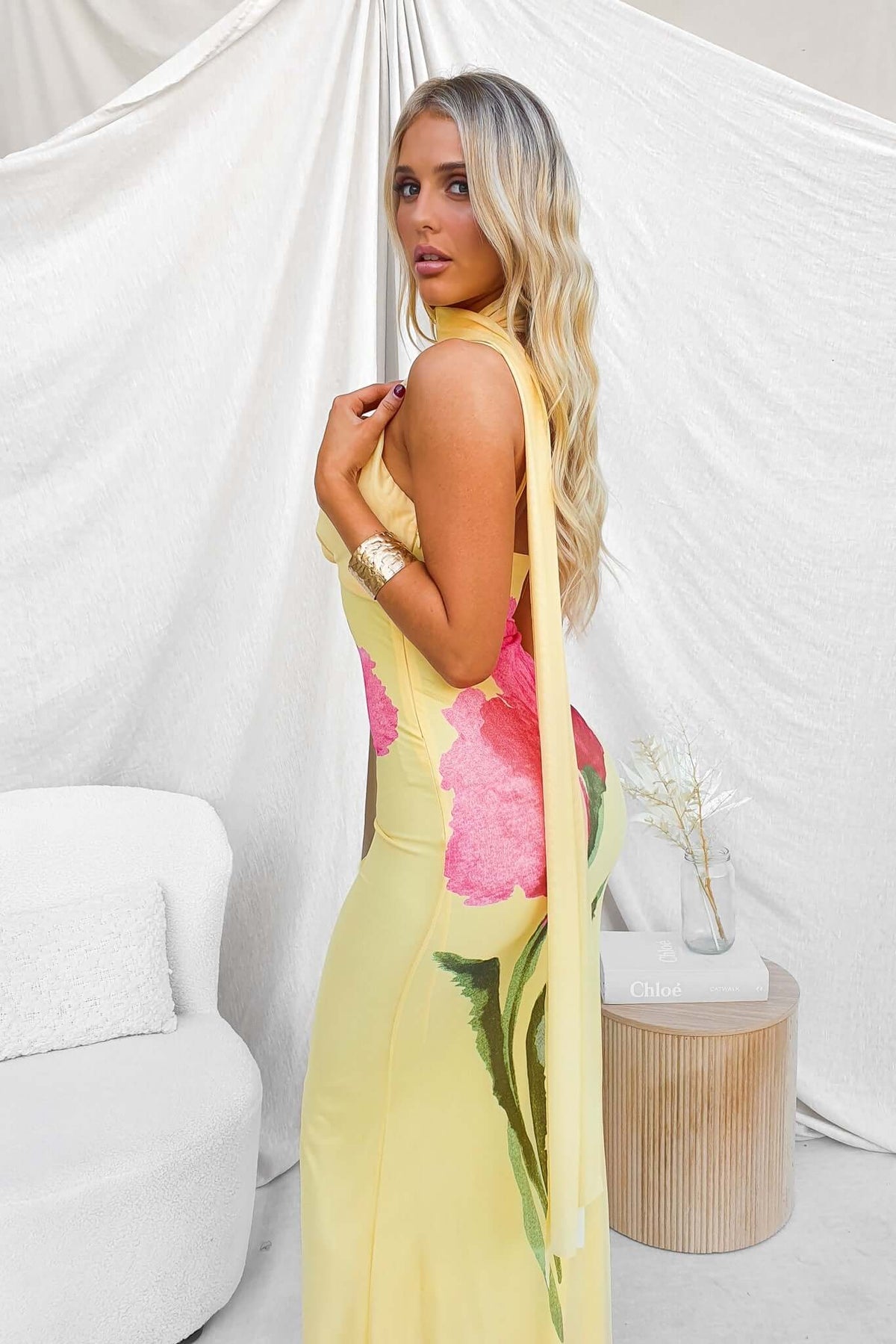 Larne maxi dress featuring a wrap neckline, adjustable straps, and floral design in sunny yellow and pink.